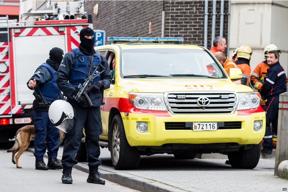 Several police officers hold guns in Molenbeek