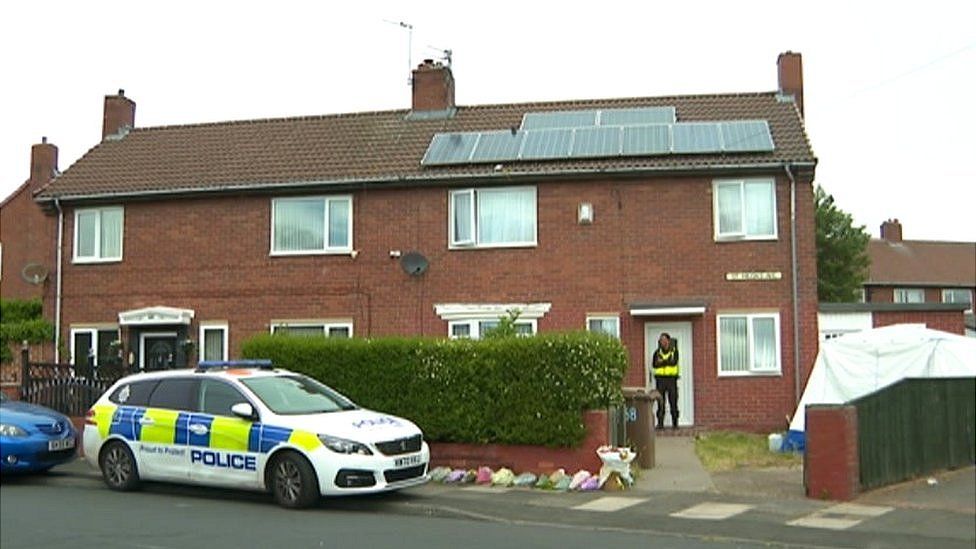 A police officer outside a house