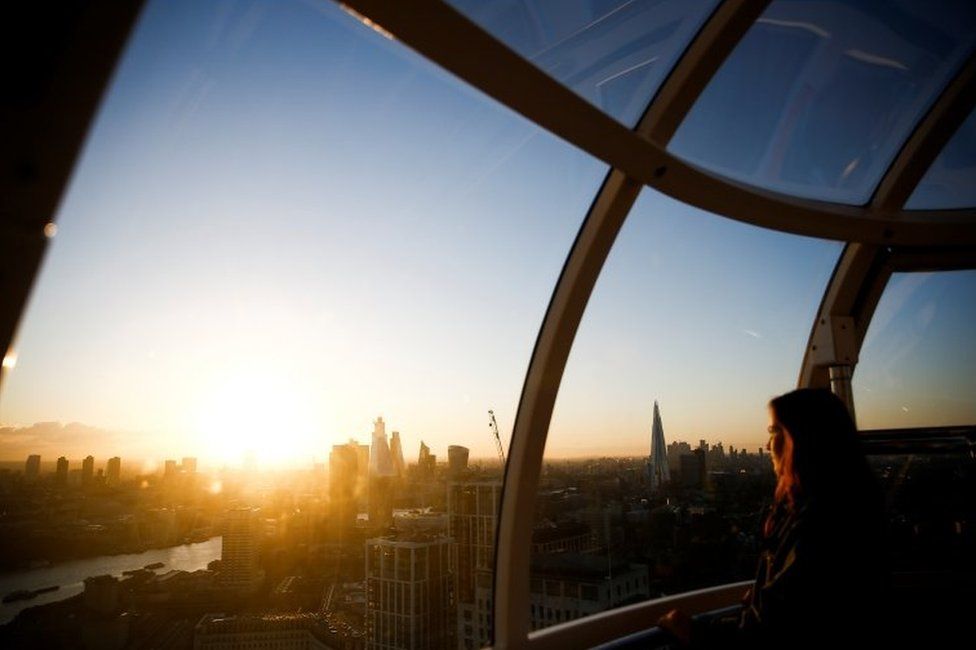A woman looking out from a London Eye pod