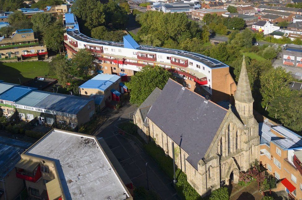 Aerial view of a church surrounded by flats