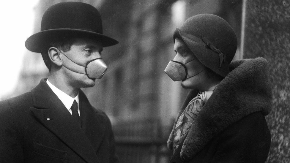 Two people wearing surgical masks