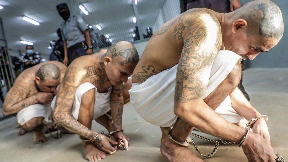 Prison agents guard gang members as they are processed at their arrival after 2000 gang members were transferred to the Terrorism Confinement Center