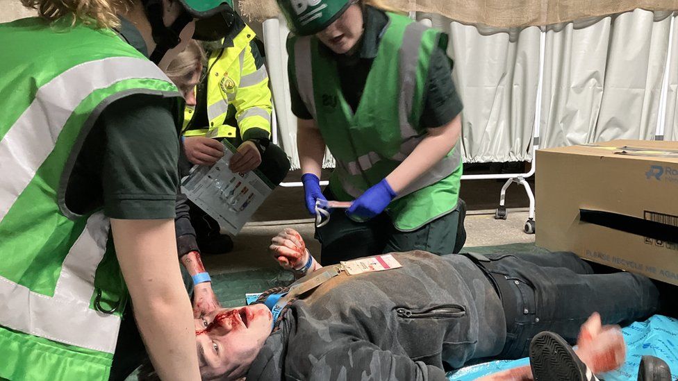Students treat injured man in mock zombie exercise