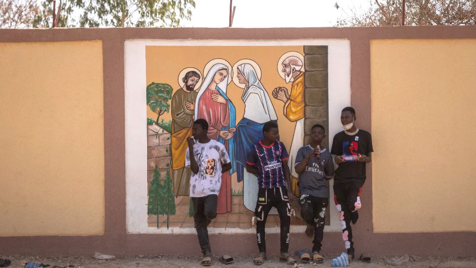 Boys in front of a religious mural outside Ouagadougou, Burkina Faso - Sunday 5 February 2023