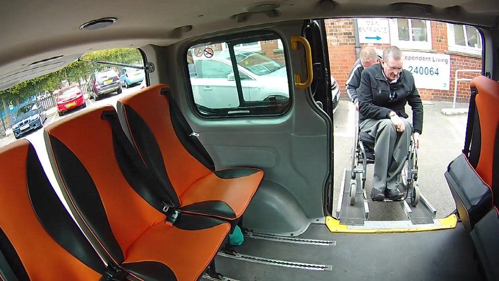 Disabled man getting into a taxi