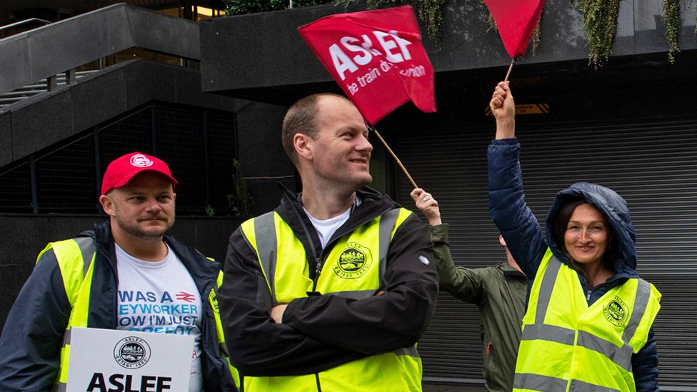 Aslef members waving flags during a strike at Euston train station