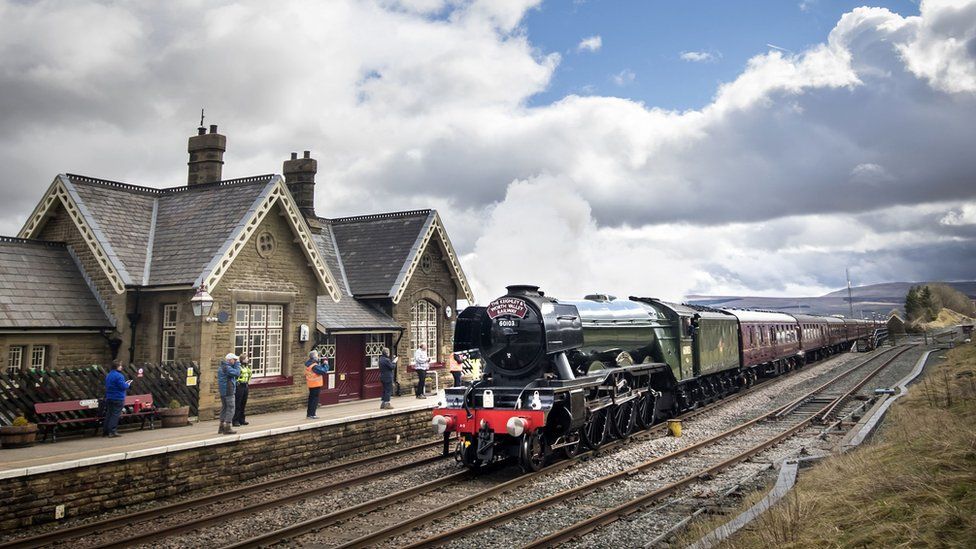Flying Scotsman passes Ribblehead Train Station in the Yorkshire Dales National Park