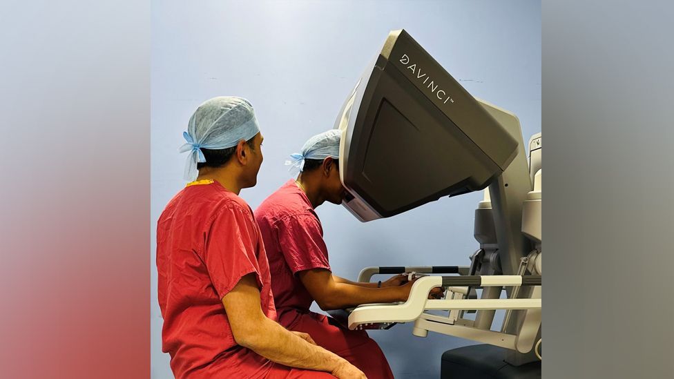 Two surgeons operating a robot