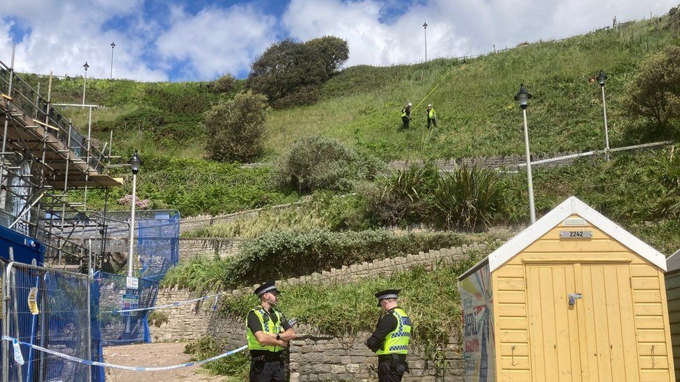 Police search teams on ropes scoured nearby cliffs for evidence