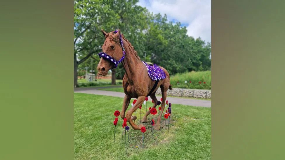 Horse sculpture with crocheted poppies below