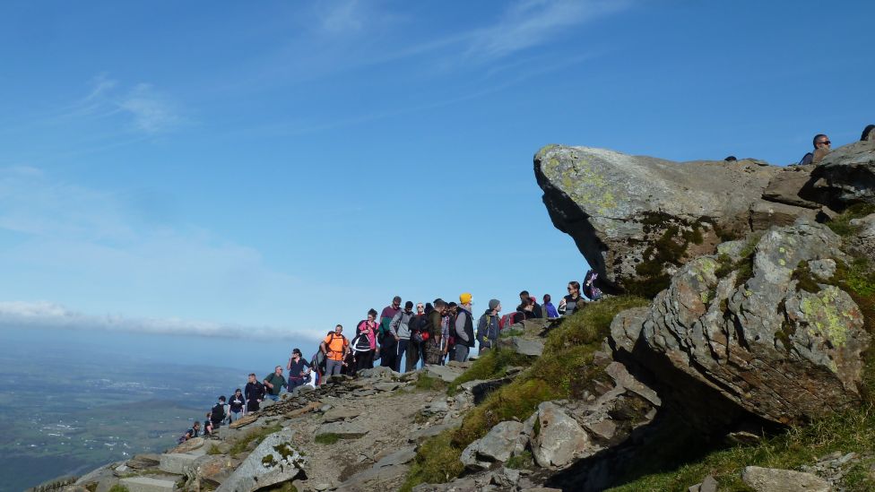 People queue to reach the summit of Yr Wyddfa, Snowdon