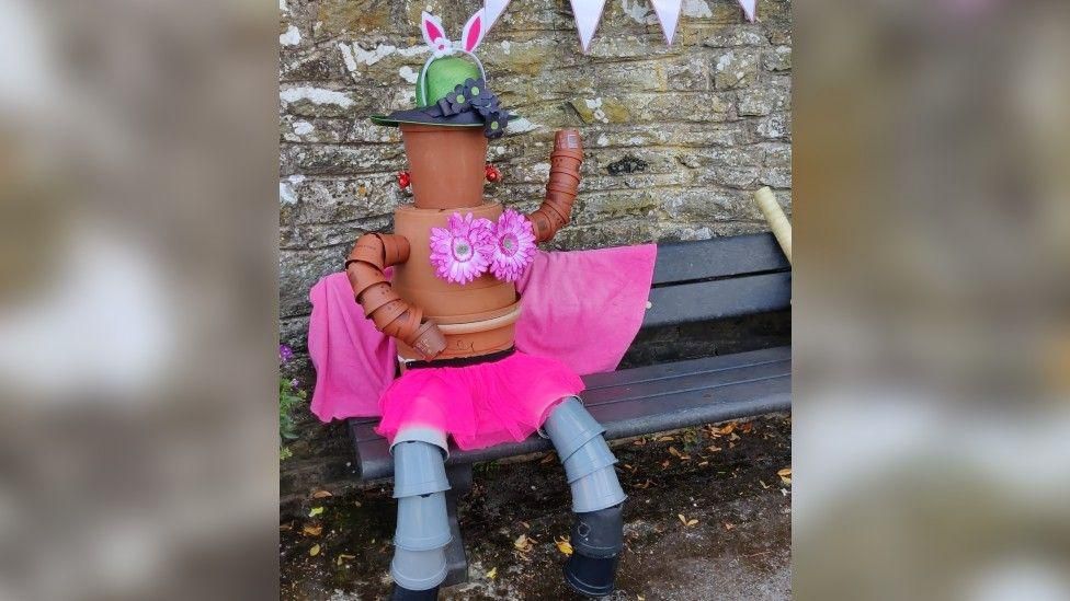 A woman made out of a plant pot wearing a tutu and bunny ears