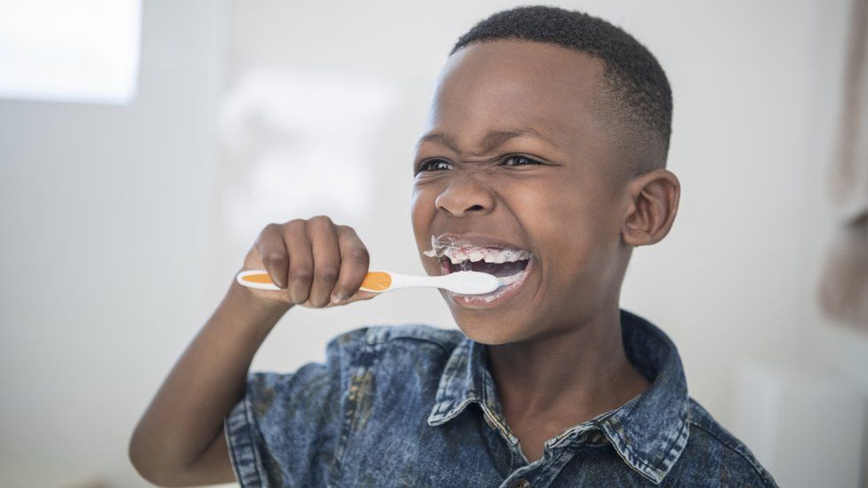 Boy cleans teeth