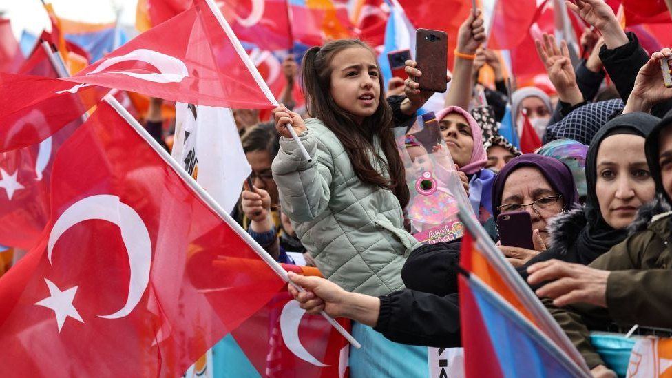 Supporters of Turkish President Recep Tayyip Erdogan wave Turkish flags and cheer during his election campaign rally in Ankara, on April 30, 2023