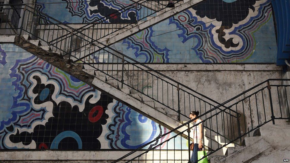 A woman walks down stairs in the centre in the centre of the Algerian capital, Algiers, on 28 July 2015