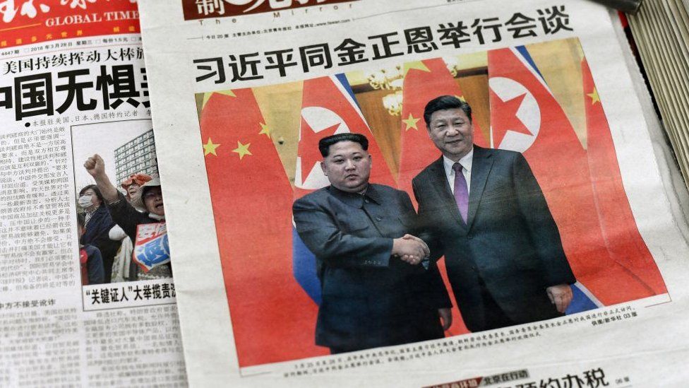 Images of Xi Jinping with Kim Jong Un, are displayed at a newspaper stand in Beijing on March 28, 2018