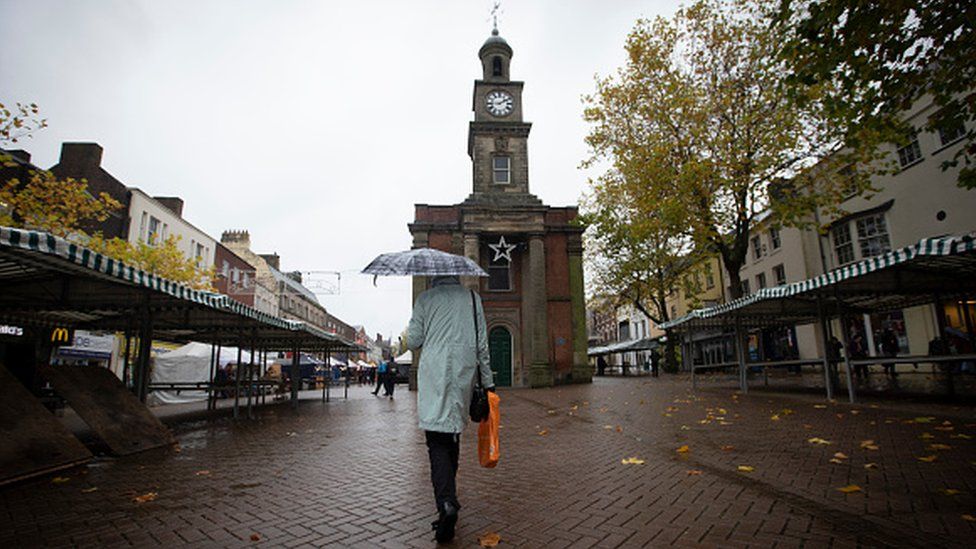 A woman walking through a market in the centre of the town of Newcastle-under-Lyme