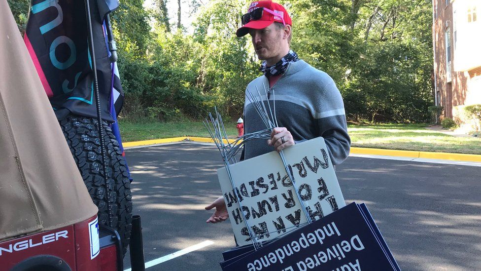 Scott Pio carries yard signs