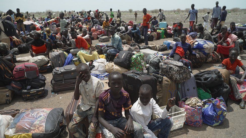 People on the runway with suitcases at Paloich Airport in South Sudan
