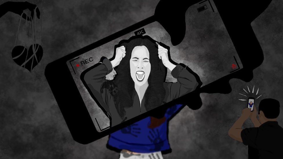 A woman screams as she pulls at her hair. Her face appears in a mobile phone . A man snaps a picture of her from the bottom right screen