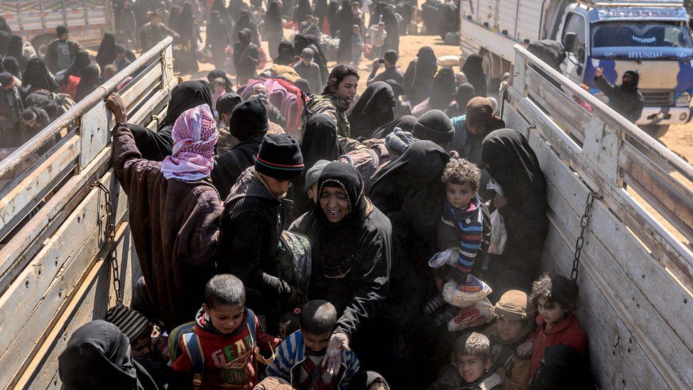 Women and children evacuated from the last IS-held village of Baghuz arrive at a screening area (6 March 2019)