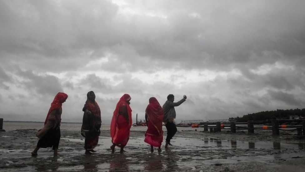 Hindu pilgrims walk back from the dock after a ferry service to Sagar Island was suspended due to the approaching Cyclone Bulbul in Kakdwip in West Bengal state
