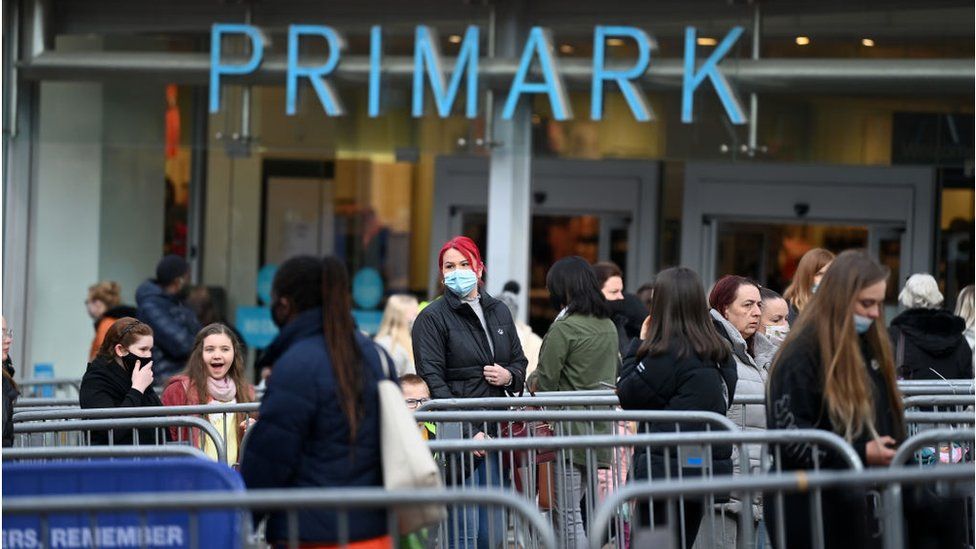 Покупатели стоят в очереди возле Primark в Сток-он-Трент