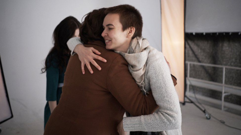 Photographer Dasha Buben greets one of the women arriving to the photo shoot