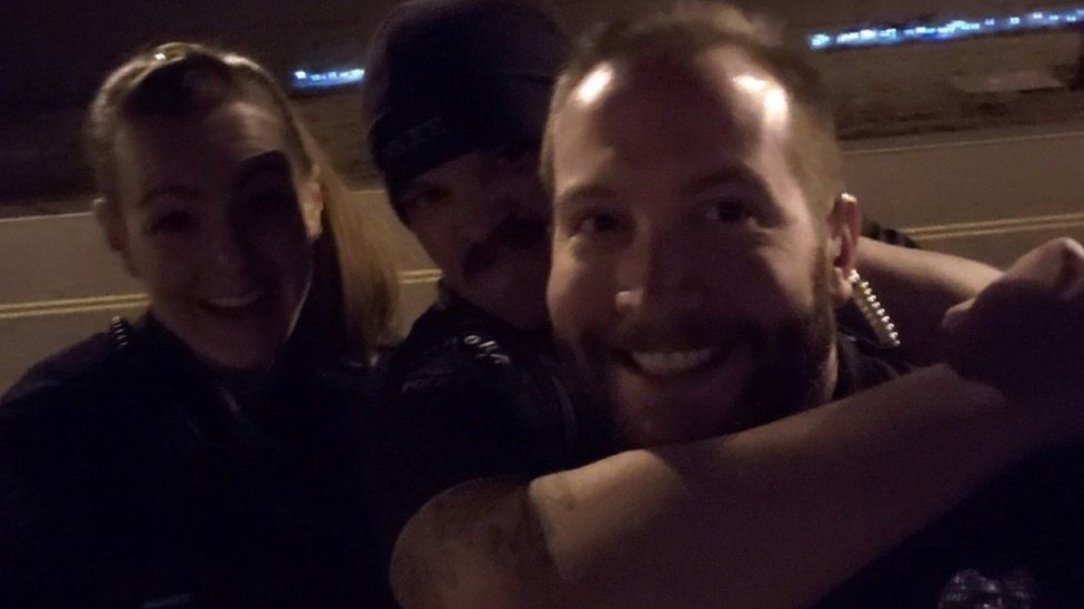 Former Aurora Police Department officers Erica Marrero, Jaron Jones and Kyle Dittrich re-enact a chokehold near a memorial to Elijah McClain, in Aurora, Colorado, in October 2019.