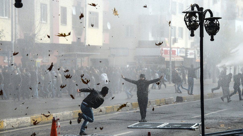 Kurds clash with the Turkish police as they protest against the recent curfews imposed on Kurdish towns