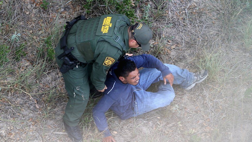 A US Border Patrol agent apprehends an undocumented immigrant near Falfurrias, Texas, on 25 July 2014