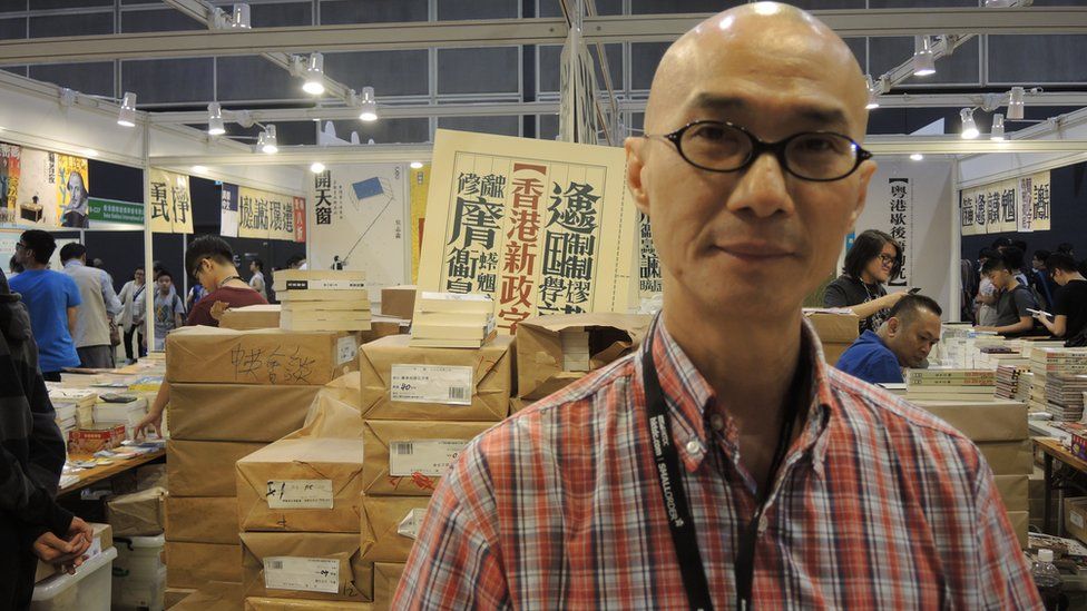 Pang Chi-ming, chief of the local publishing company Subculture Ltd stands in front of the booth. In the background the cover of Hong Kong's New Political Vocabulary can be seen
