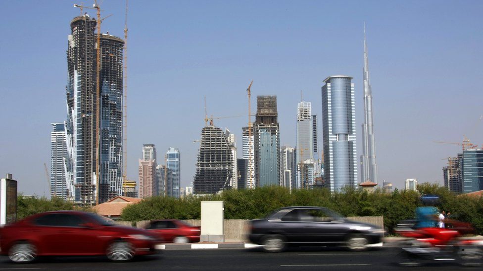 Cars drive past skyscrapers under construction in the Gulf emirate of Dubai on November 27, 2009