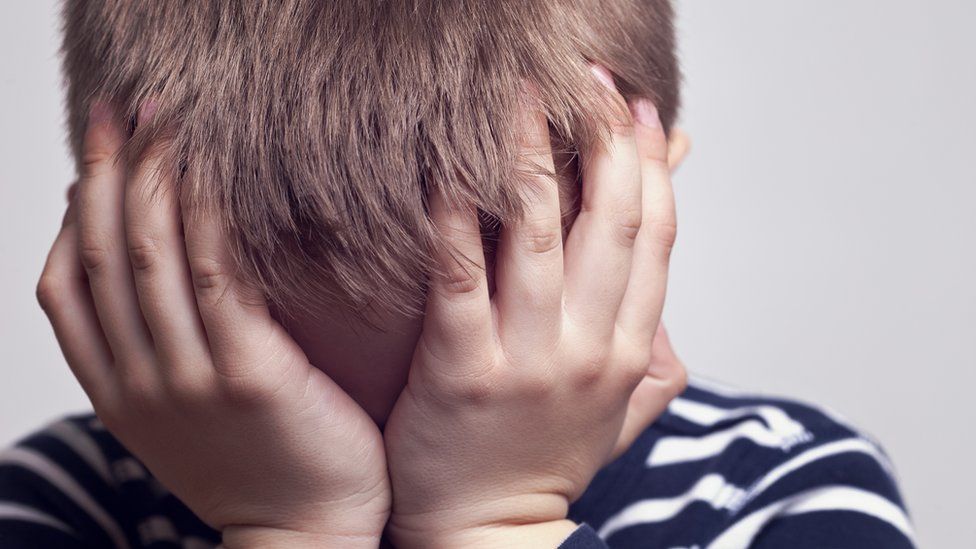 Boy with head in hands