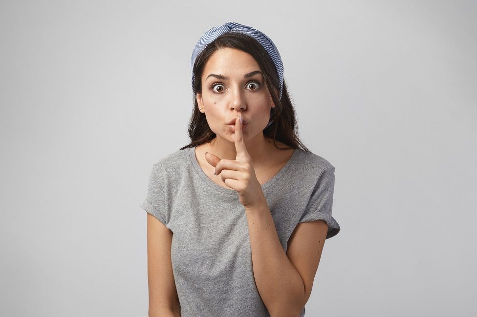 Woman with finger on lip asking for silence