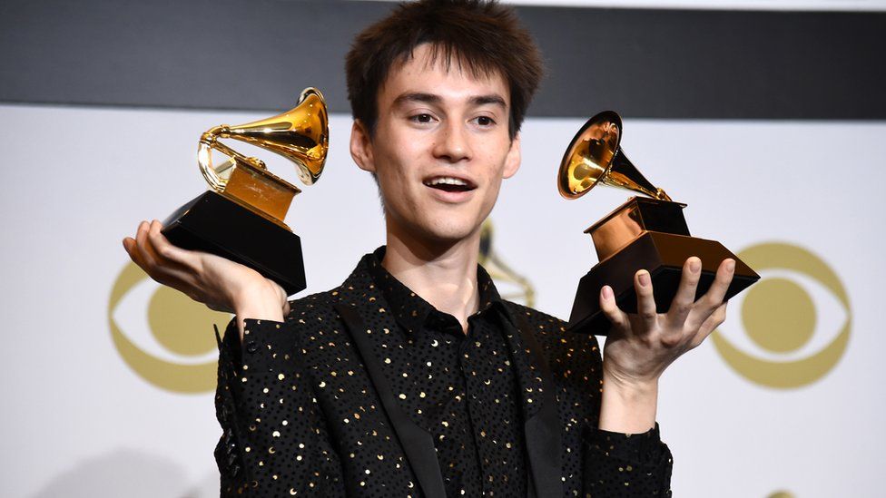 Jacob Collier holding two Grammys