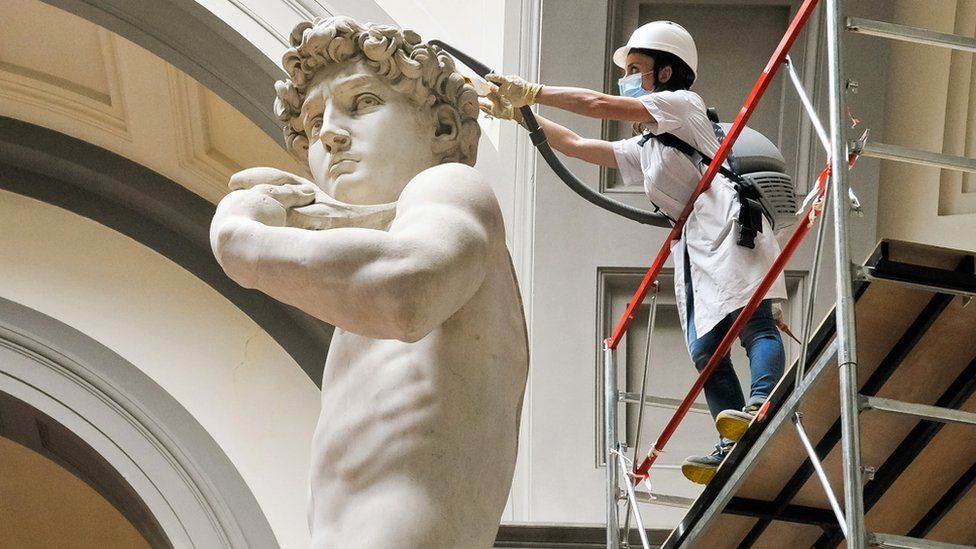 A restorer cleans the head of Michelangelo's David statue