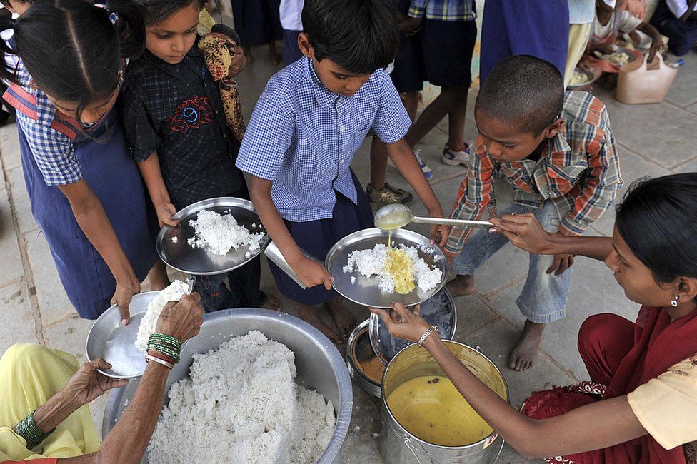 Индийские школьники получают еду в рамках программы «Mid Day Meal» в государственной начальной школе в Хайдарабаде 23 июня 2010 г.