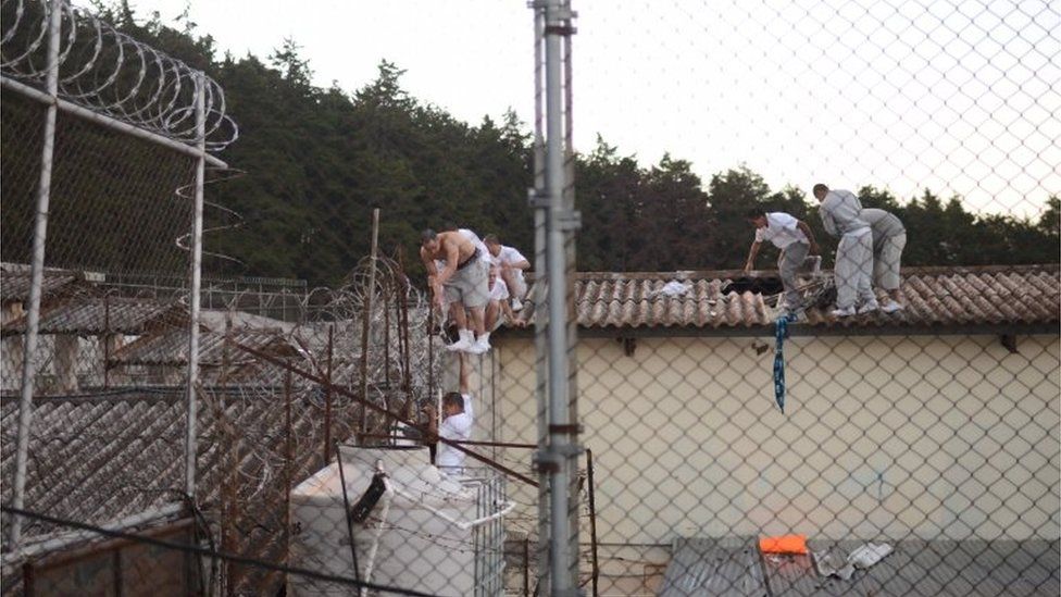 Inmates walk on the roof during a riot in a juvenile detention centre in San Jose Pinula, east of Guatemala City, on March 19, 2017.