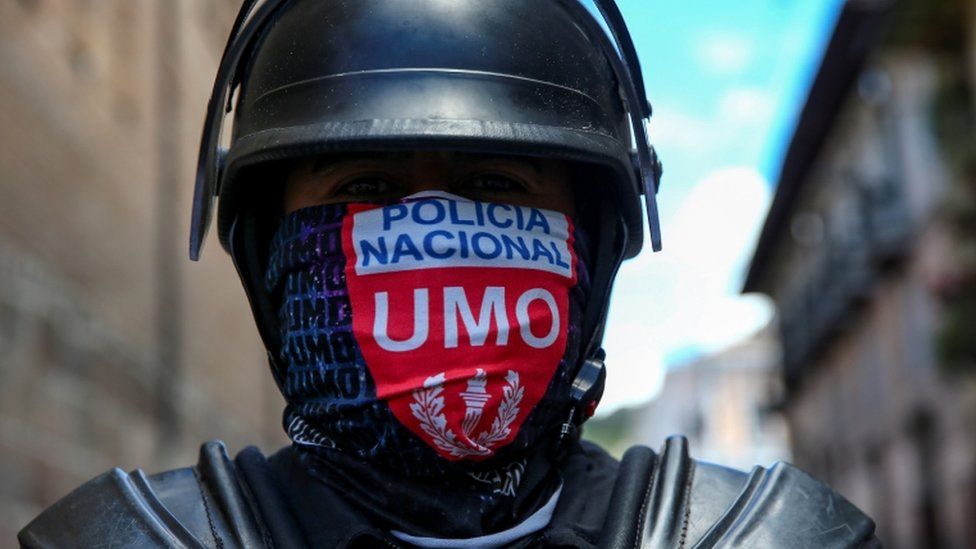 A member of the national police wears a face covering during protests in Quito