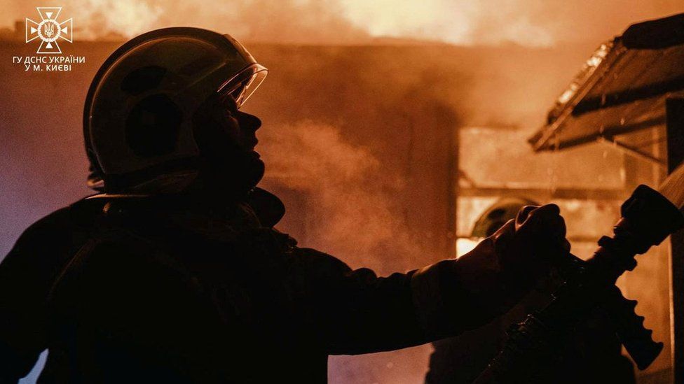 The staff of the State Emergency Service of Ukraine and the police work together to rescue people from a burning building after a recent shelling amid Russia's attack in Kyiv on 13 December