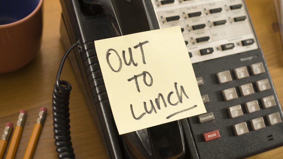 A generic image of an "out to lunch" note stuck on a work phone