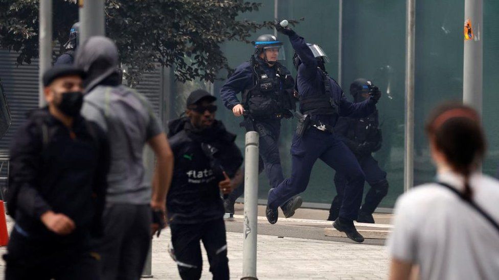 Policías antidisturbios franceses reaccionan en medio de enfrentamientos con manifestantes durante una marcha en homenaje a Nahel, una adolescente de 17 años asesinada por un policía francés durante un control de tráfico, en Nanterre