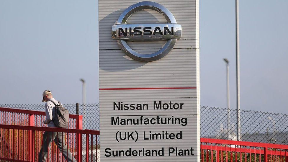 Workers leave the Nissan car plant after finishing their shift in Sunderland.