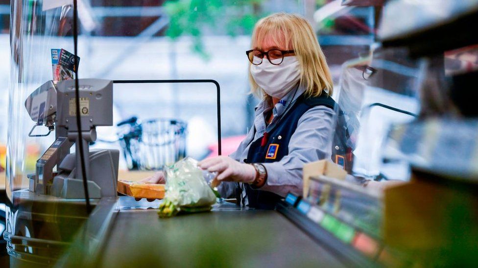 A cashier wearing a mask at Aldi