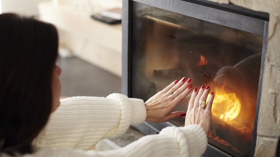 Woman heating hands at fire