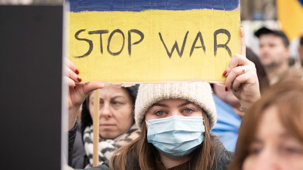 A pro-Ukraine demonstrator holds a sign reading "stop war"
