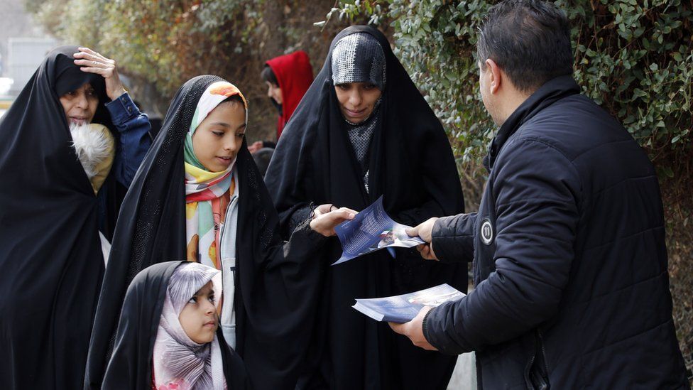 Iranian campaign workers hand out electoral leaflets for a candidate in the upcoming parliamentary polls, in Tehran, Iran (23 February 2024)