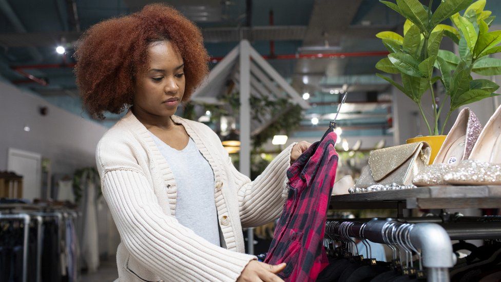 Woman picking out a top in a clothes store