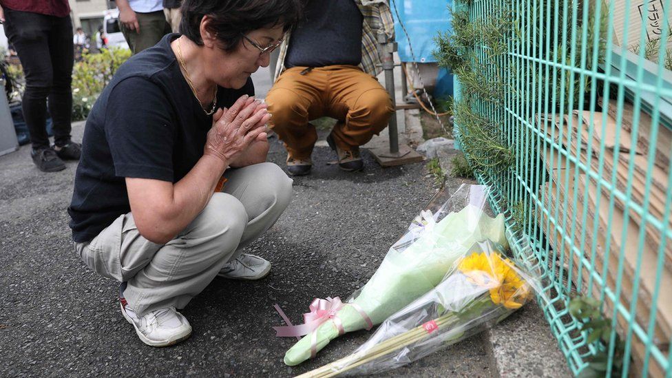 Japan's Yasuko Atsukata, who witnessed the crime scene where a man stabbed 19 people, lays flowers